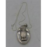 A Silver locket with embossed owl to the lid on silver chain