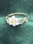 A Peridot and diamond ring in a daisy style and 9ct gold setting