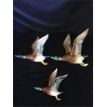 A set of three wall mounted Bretby pottery graduated flying ducks; bearing impressed mark verso