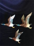 A set of three wall mounted Bretby pottery graduated flying ducks; bearing impressed mark verso