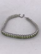 A silver and peridot line bracelet