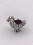 A silver pincushion in the form of a Dodo