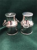 A pair of salt and pepper pots in the shape of milk churns