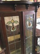 An early 20thC Art Nouveau mahogany display cabinet, the canopied upper part surmounted by a pierced