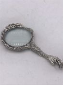 A silver hand held magnifying glass in the Art Nouveau style