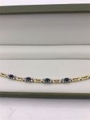 A 14ct yellow gold sapphire and diamond panelled bracelet