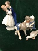 A selection of Royal Copenhagen china to include a goose, children reading, a boy playing and a