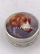 A silver round pill box with enamel plaque depicting a dog