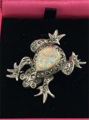A silver frog brooch set with marcasite's and opal panel.