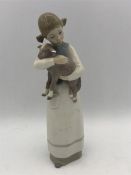 A Lladro figure of a girl holding a lamb.