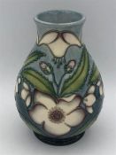 A small Moorcroft vase, blue green with cream flowers 13cm tall.