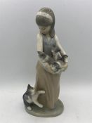 A Lladro figure of a young girl with kittens.
