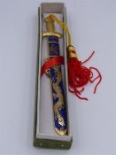 An Oriental brass and enamel cased paper knife.