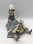 A Lladro figure of a young girl with ducks over her skirts.