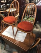 A Blonde Ercol dining table with four matching Windsor chairs