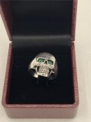 An unusual skull shaped ring with Emerald eyes.