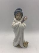 A Lladro figure of a child wrapped in a bath towel with brush and duck.