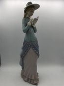 A tall Lladro figure of a young woman reading her book