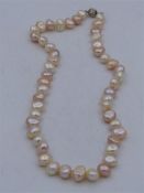 A Pink and Cream Fresh water pearl necklace with silver ball clasp.