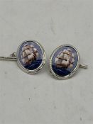 A pair of silver and enamel cufflinks with pictorial image of ships at sail