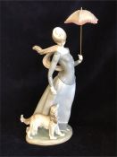 A tall Lladro figure of a lady with a parasol and an Afghan hound