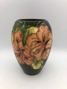 A Green Moorcroft vase 17cm tall with orange flowers