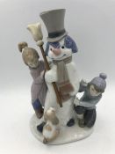 A Lladro figure of a snowman with children and puppy