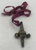 An antique silver children's rattle and whistle on a purple ribbon.