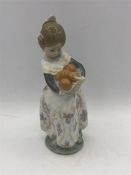 A Lladro figure of a girl carrying oranges,