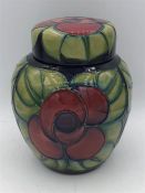 A Moorcroft ginger jar with red poppies and green leaves.