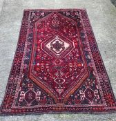 An Iranian hand woven red ground rug