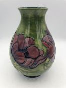 A Moorcroft vase, flower on green grounds 18cm tall.