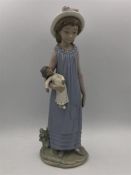 A Lladro figure of a young girl with a doll.