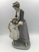 Lladro figure of a woman comforting a crying girl.