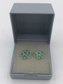 A Pair of silver earrings in a flower shape.