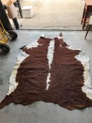 A cow hide rug, brown and white. 190cm x 58cm.