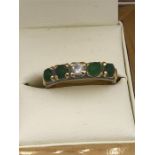 A Chinese Emerald and diamond ring on a yellow gold setting.