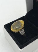 A Citrine ring with diamond shoulders on a 9ct yellow gold mount