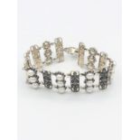 A silver filigree bracelet set with three rows of pearls and marcasites