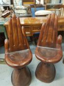 Two hard wood chairs, carved in the shape of hands