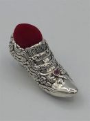 A silver pin cushion in the form of a ladies shoe