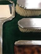 A Four piece silver dressing table set by Walker & Hall Birmingham 1965, comb AF.