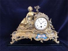 A Gilt metal clock with decorative enamel front plate
