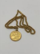 A 1928 gold sovereign coin on an Asian gold chain and mount (Total weight 31.6g)