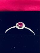 An 18ct white gold ring set with central ruby and surrounded by diamonds