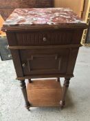 A bedside table with a red marble top.