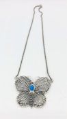 A silver necklace in the form of a butterfly set with ruby and opal.