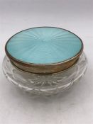 A glass dressing table jar with enamel on silver lid