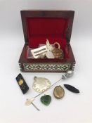 A Jewellery box containing a silver glove hook, jet brooch and assorted items.