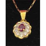 A yellow gold pendant necklace set with ruby and diamonds on gold chain.